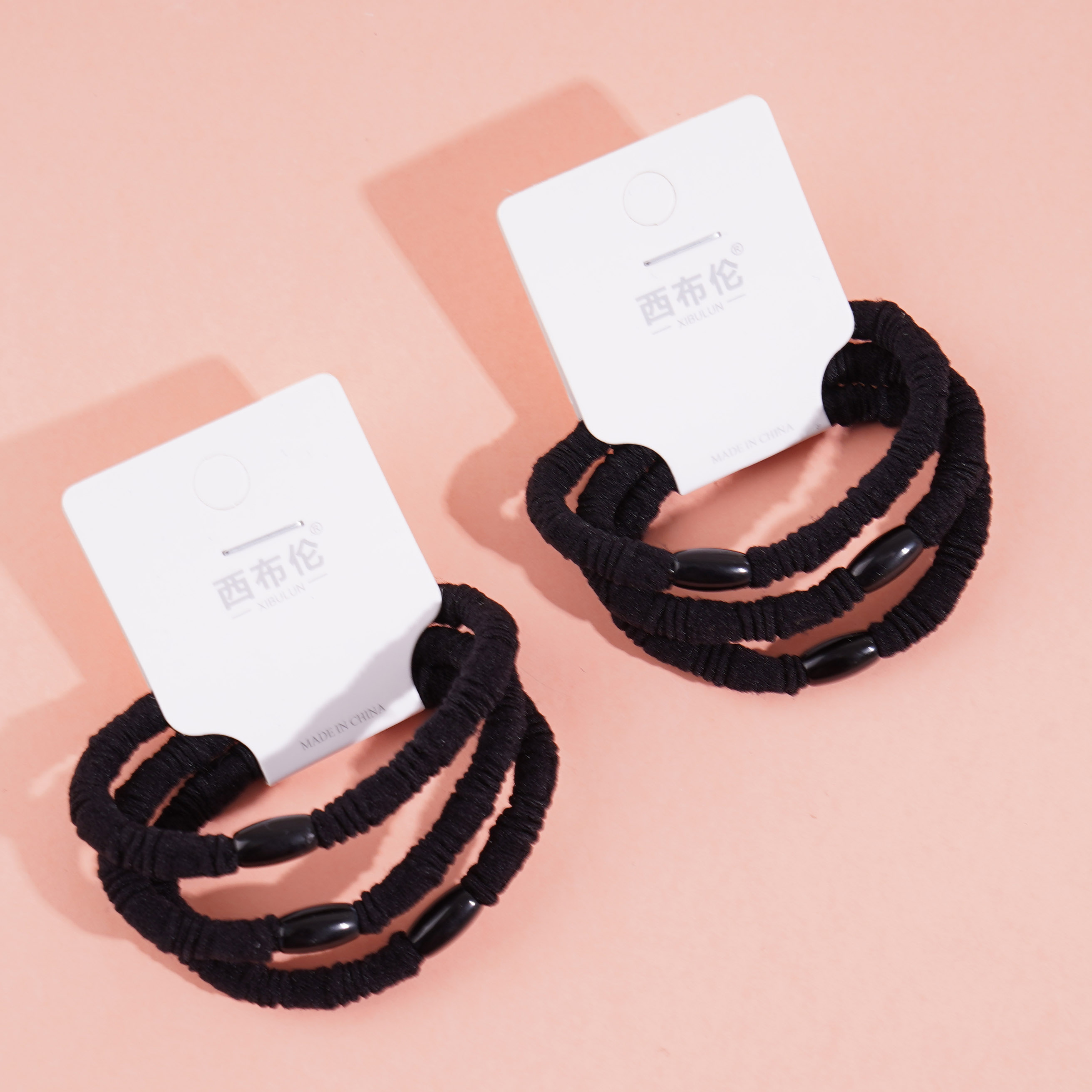 3 black round bead head rubber bands