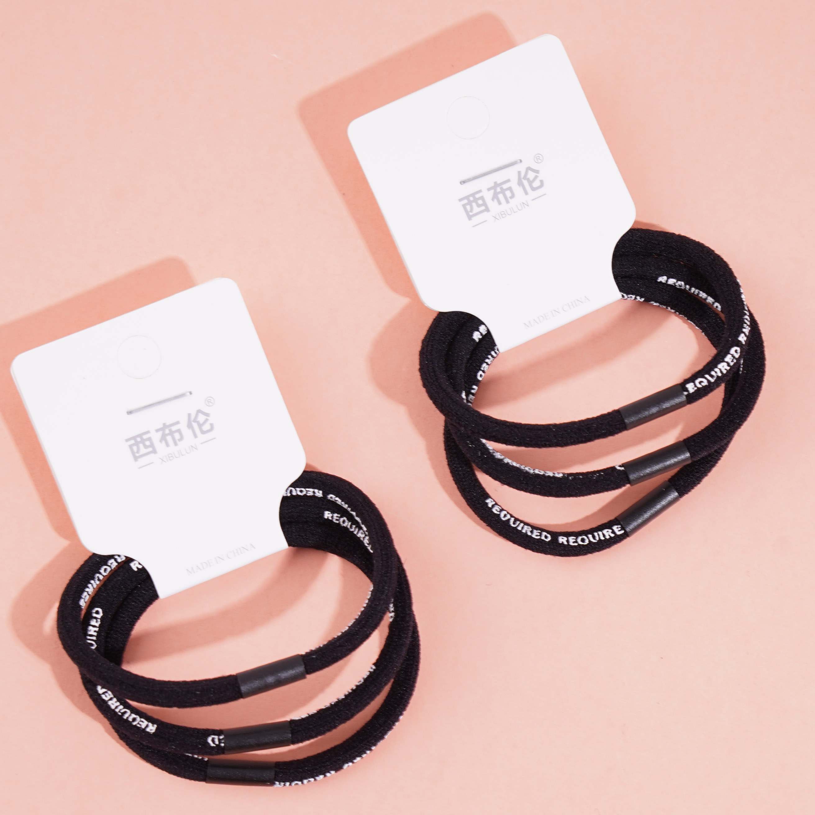 3 black letter-headed rubber bands