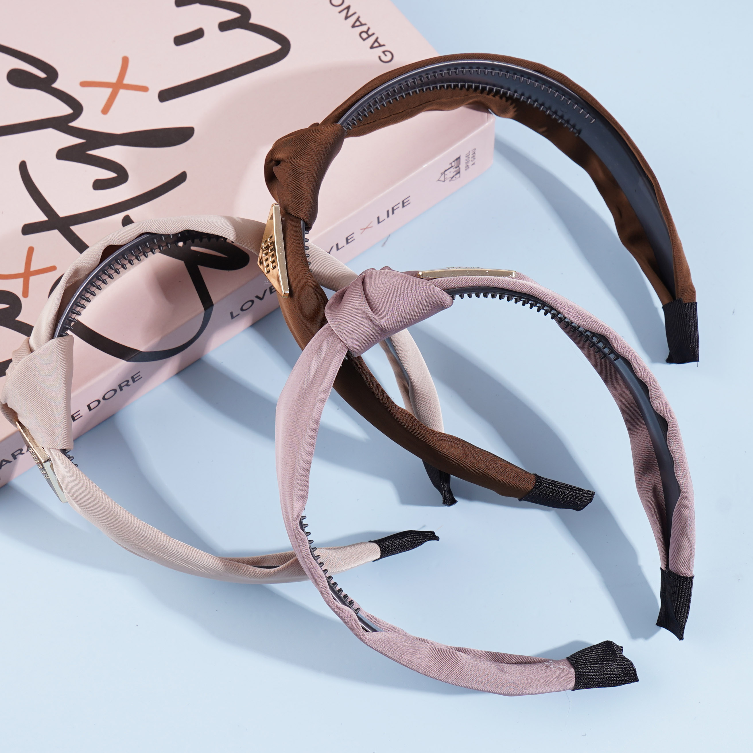 A square MIU-branded headband with a bow-shaped hair clip