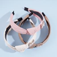 Une pince à cheveux en forme de nœud de perles avec des plis.