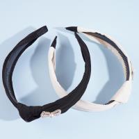 Une pince à cheveux en forme de nœud de perles avec des plis.