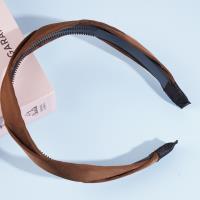 Un accessoire de cheveux en forme de double nœud avec une bordure brillante.