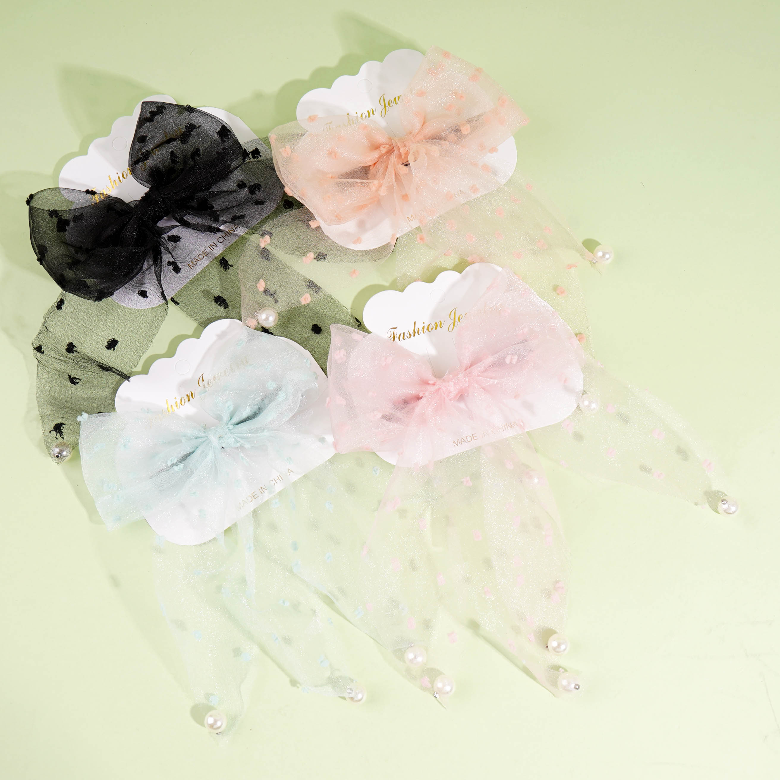 A duck clip with a small fluttering ribbon and dotted pearls