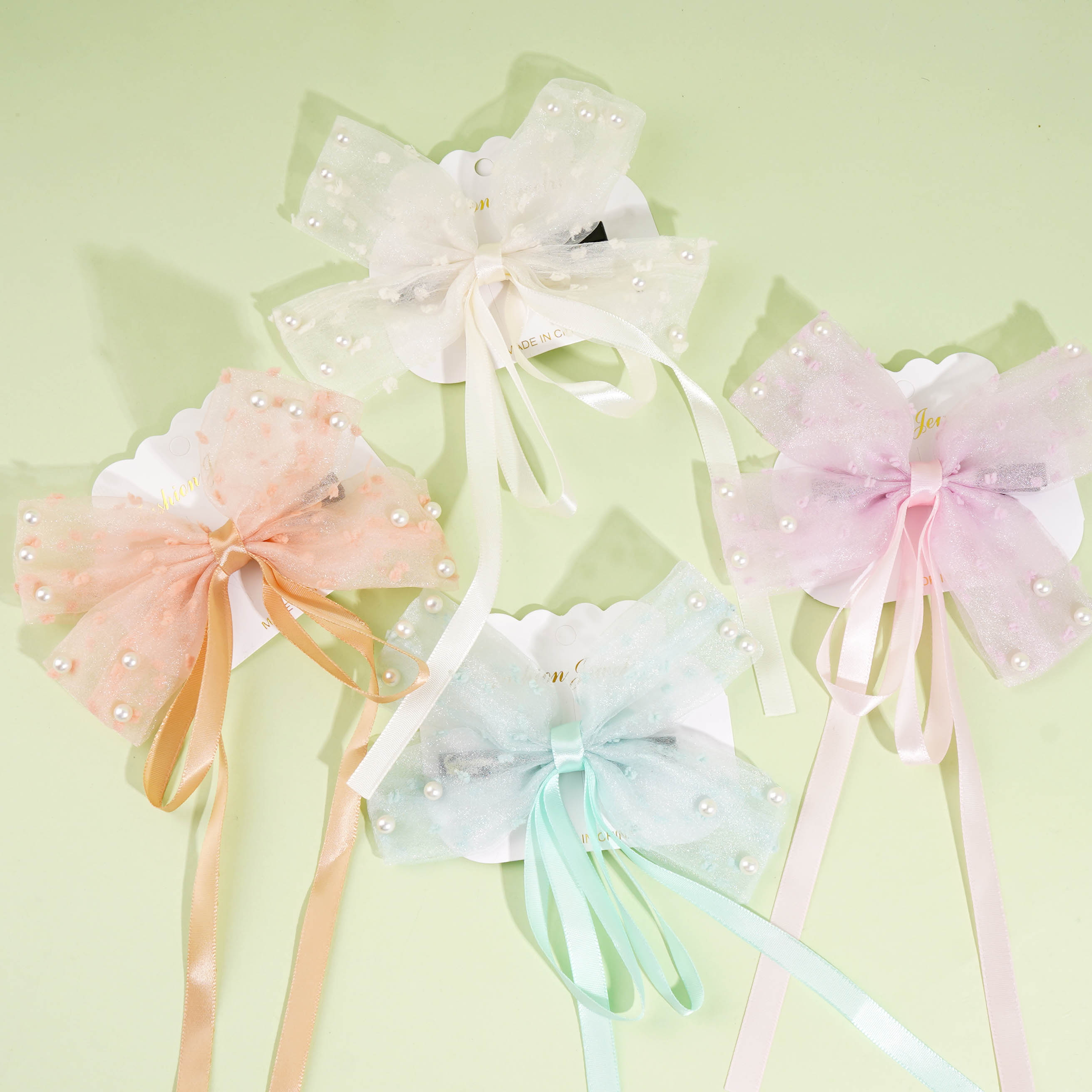 A duck-shaped clip with a bow-knot design, featuring a studded pearl embellishment on the front