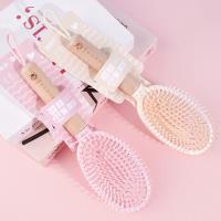 Une brosse à air comprimé avec une poignée en bois ovale et une corde de suspension, datant de 1978.