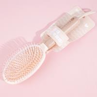 Une brosse à air comprimé avec une poignée en bois ovale et une corde de suspension, datant de 1978.