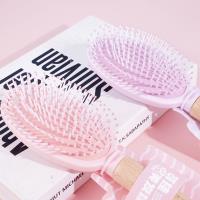 Une brosse à air comprimé avec une poignée en bois ovale et une corde de suspension, datant de 1978.