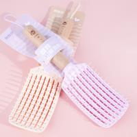 Une peigne à lanière avec un manche en bois sculpté, datant de 1985.