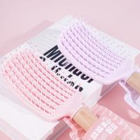 Une peigne à lanière avec un manche en bois sculpté, datant de 1985.