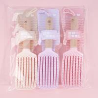 Une peigne à lanière avec un manche en bois sculpté, datant de 1985.