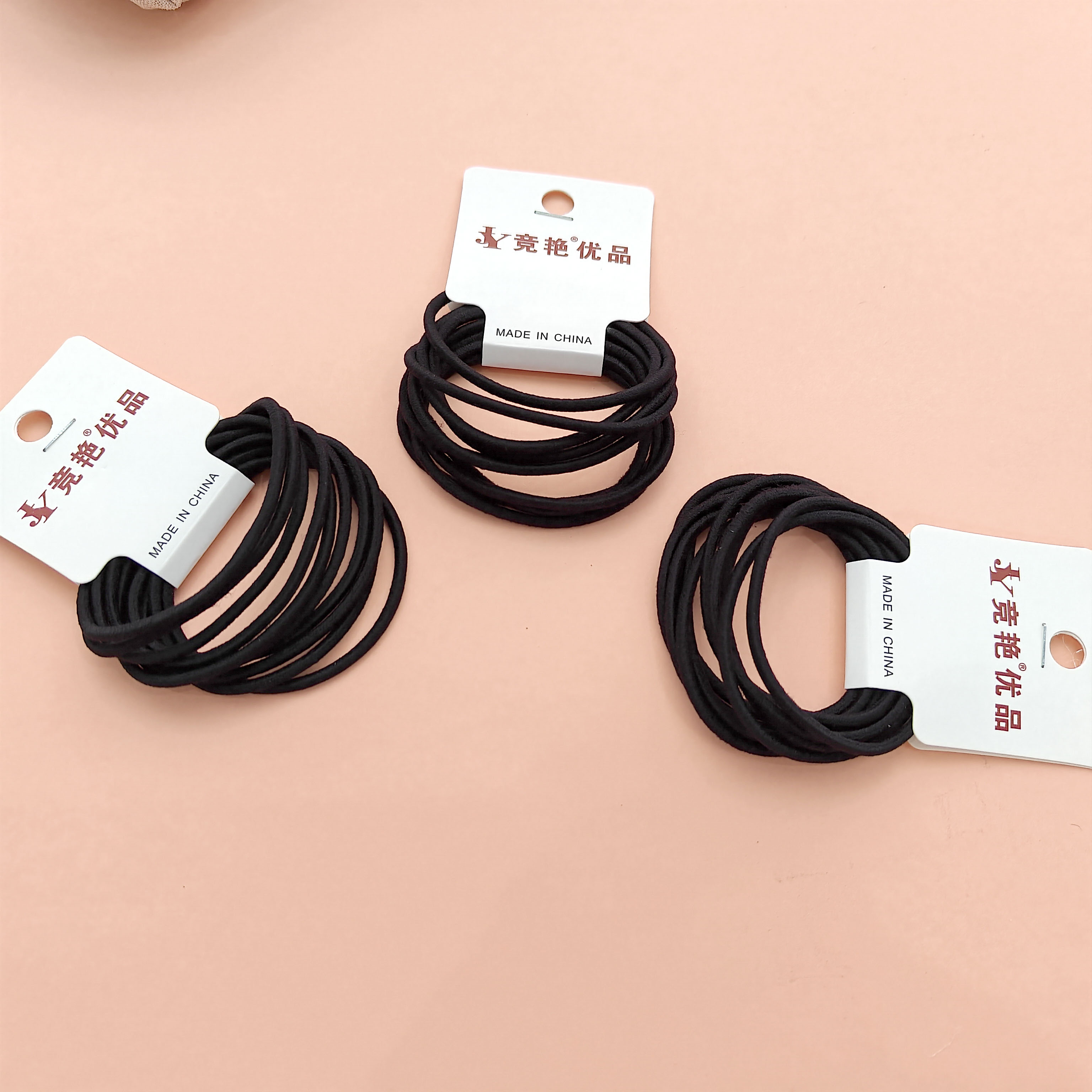 10 black thin hair bands with a loop at the end of the cord