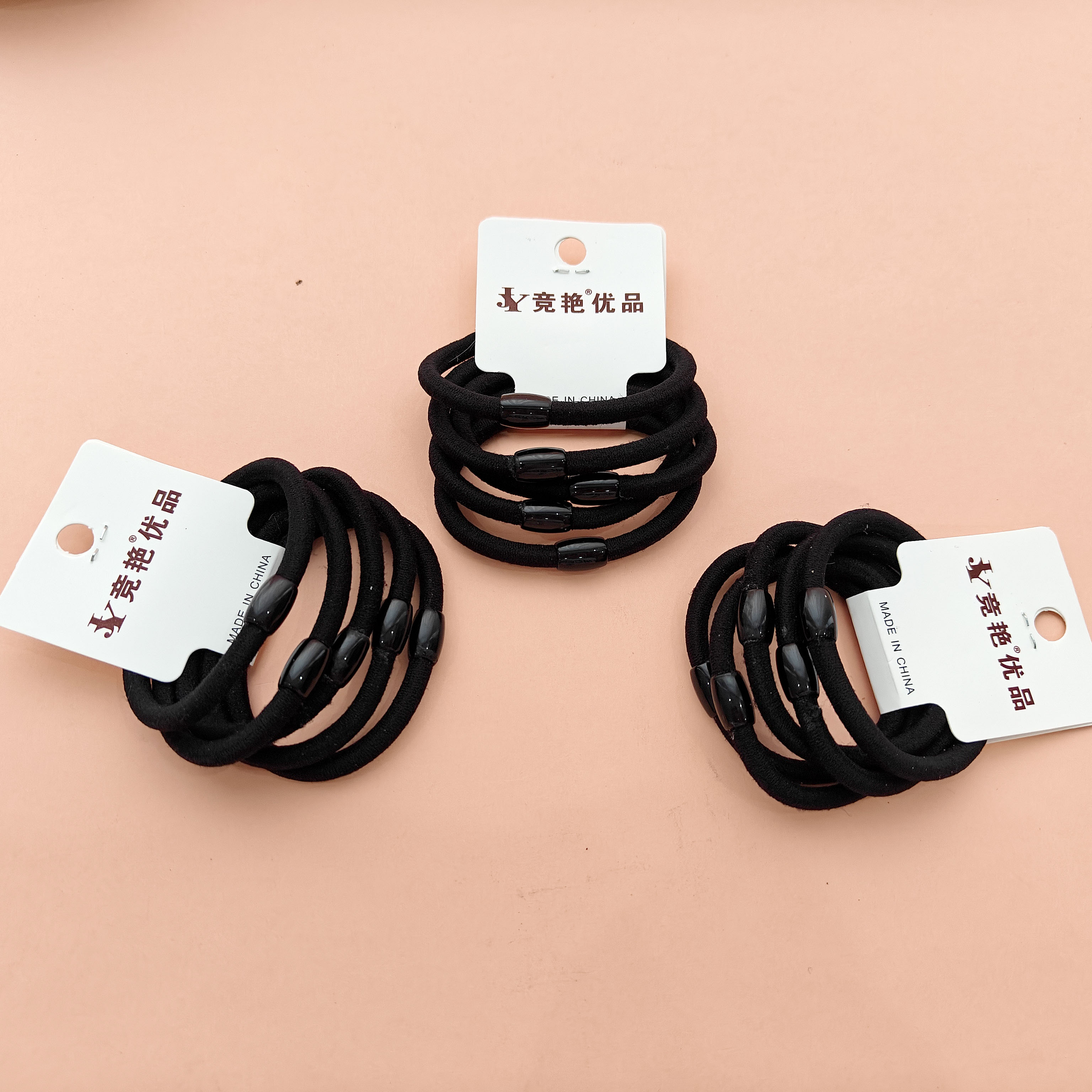 5 black beads strung on a thick-headed rope