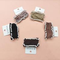 Un élastique à cheveux avec deux rangées de perles incrustées.